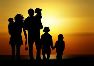 family together with sunset behind them