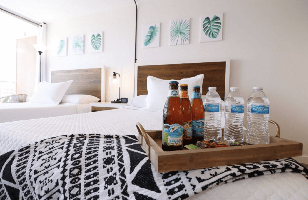 Beer and water bottles on a tray on guests bed in an Airbnb to make the space stand out