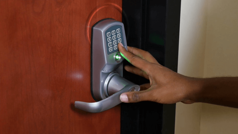 fingers keying in a numbered code for a keyless entry door lock