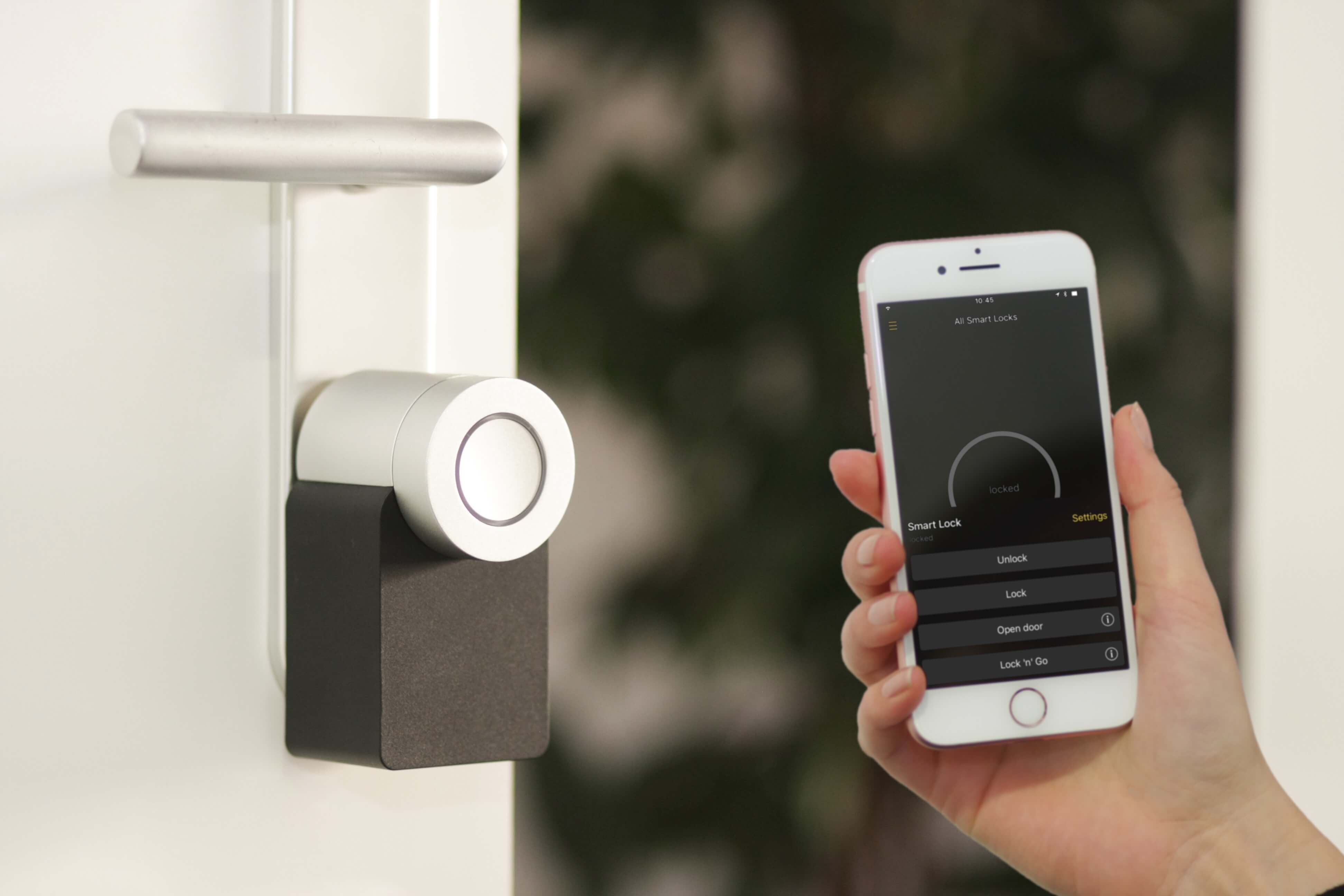 Home keyless entry with hand holding phone showing software interface