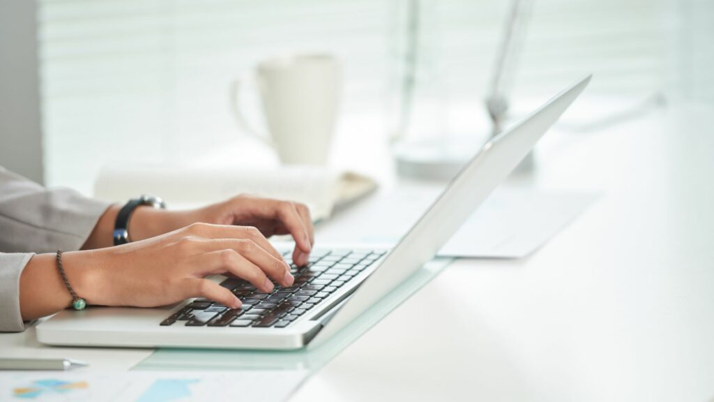 hands typing on laptop keyboard