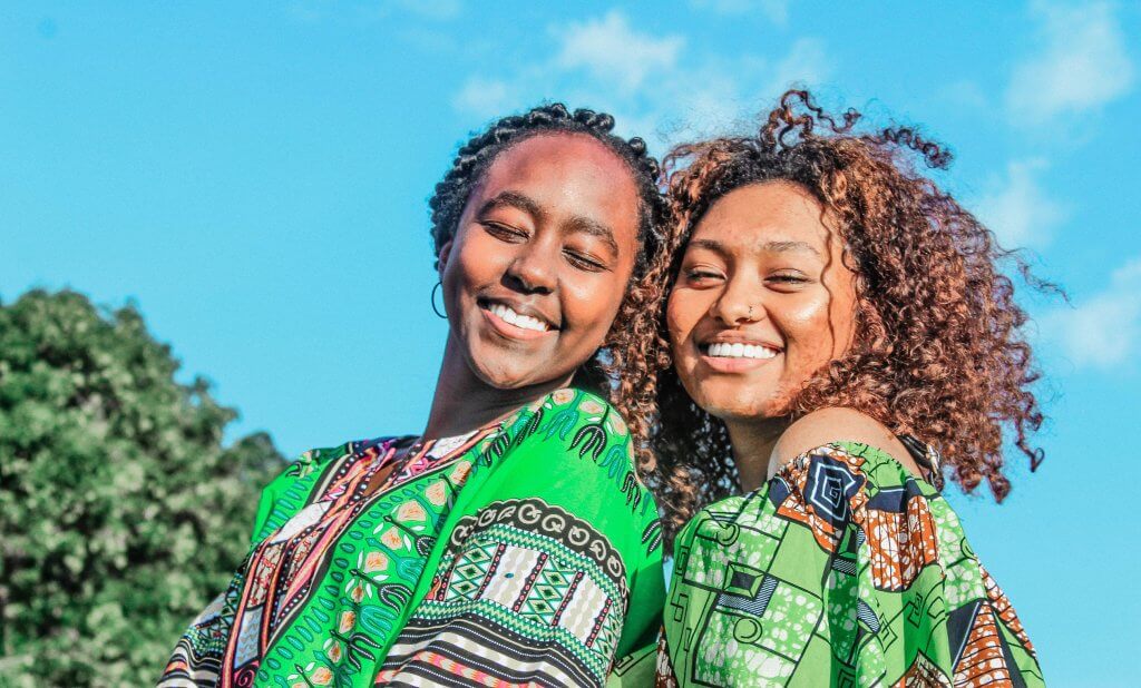 Two woman smiling. Photo by Kirschner Amao on Unsplash.