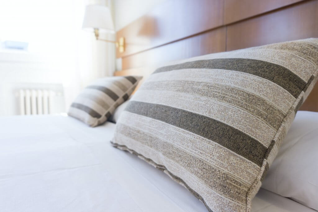 A close up of throw pillows on a hotel bed