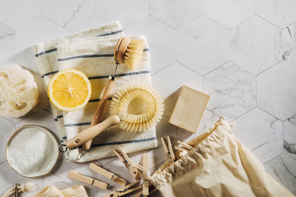 Eco friendly natural cleaning tools and products, bamboo dish brushes and lemon with baking soda.