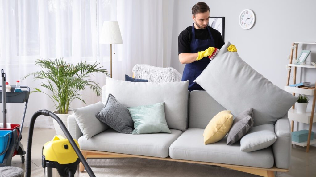 airbnb cleaner brushing couch pillows