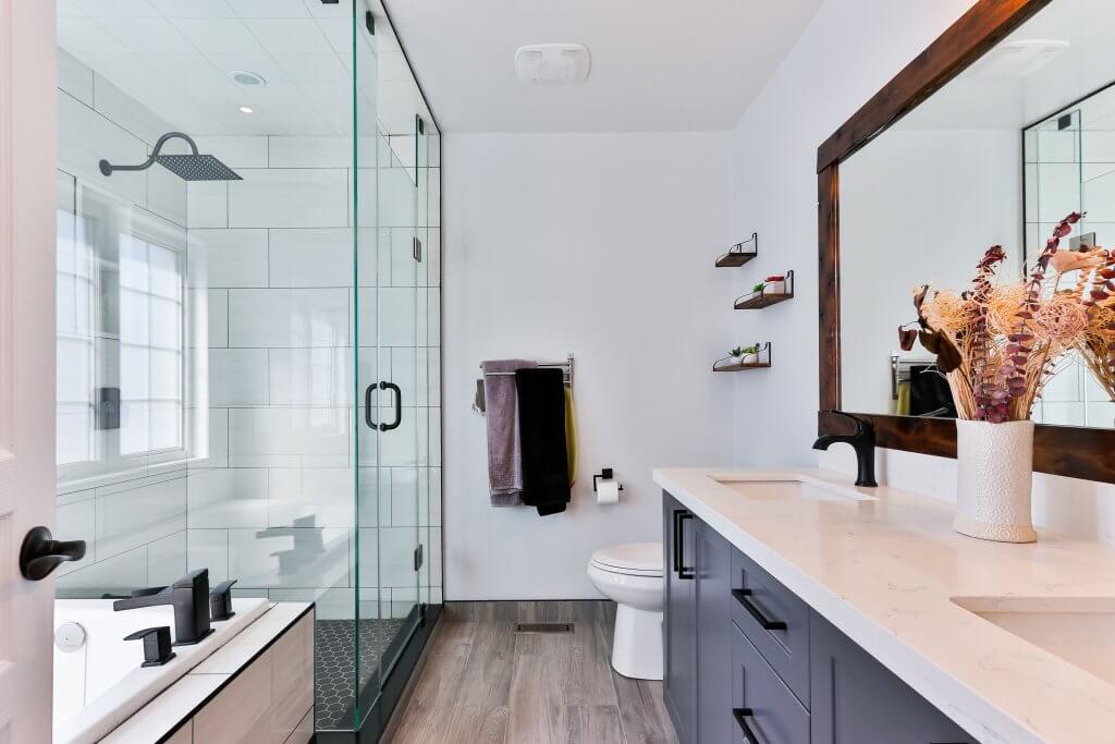 stylish bathroom with glass door shower, modern appliances, plants, and decor