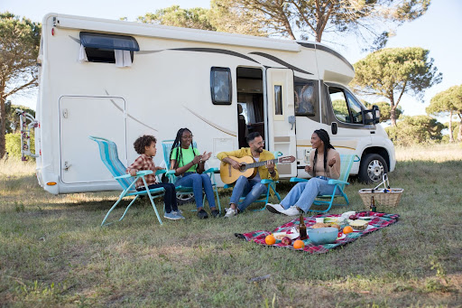 People talking and singing outside an RV