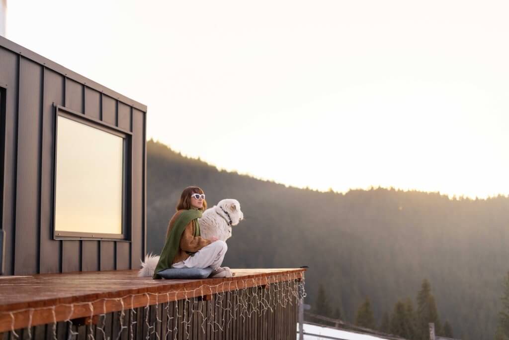 woman and dog on an airbnb tiny homes porch overlooking a mountain