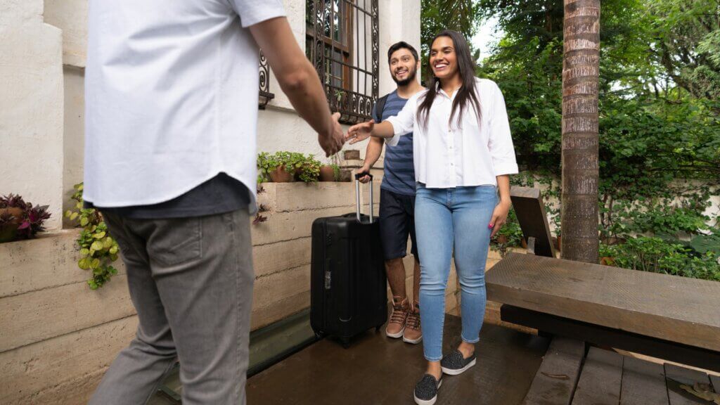 Airbnb guests shaking hands with their host. 