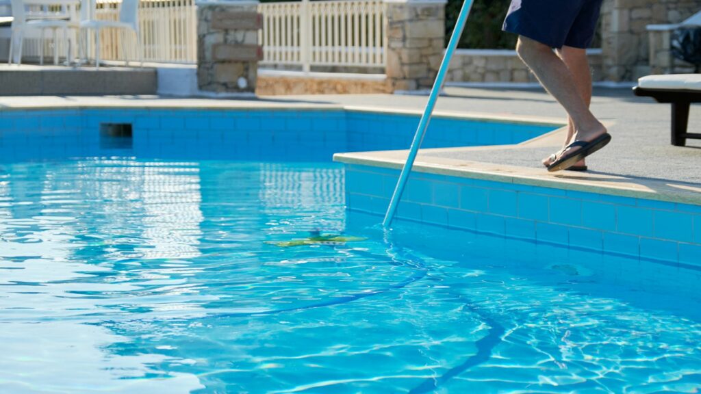 A pool cleaner skimming the water of an Airbnb pool