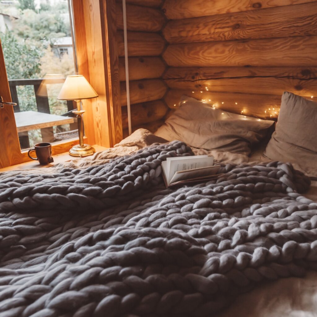 Knitted blanket on a bed in a cabin for a cozy airbnb theme