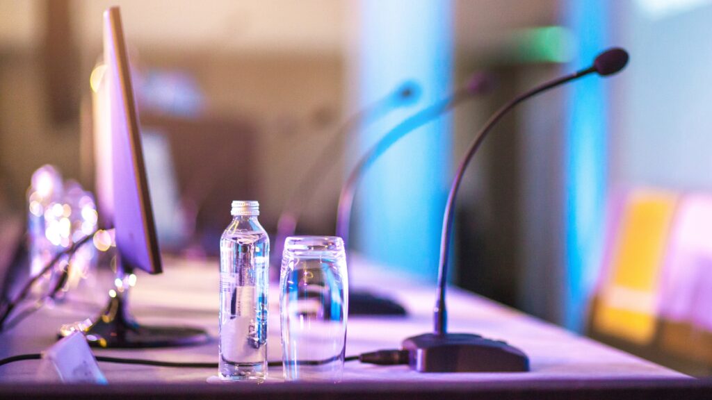 str conference table with microphones and bottles of waters