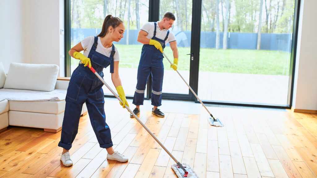 two vacation rental cleaners mopping wooden floors