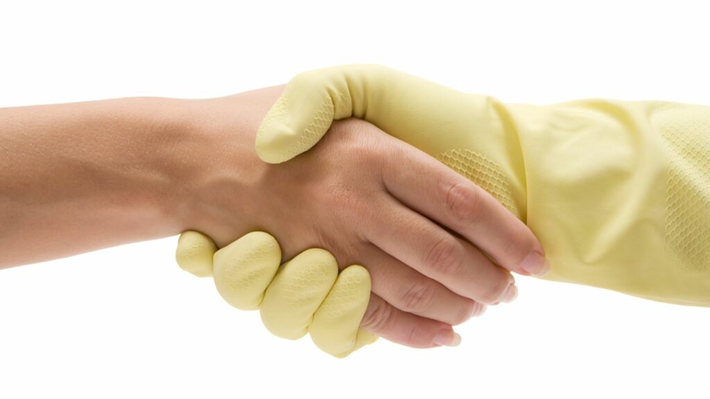 Up close image of an airbnb cleaner shaking hands with a host