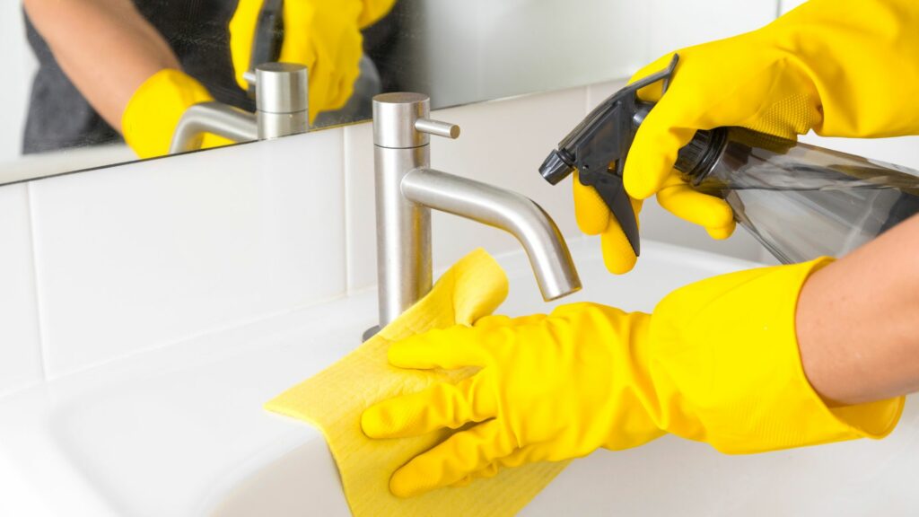 airbnb cleaner wearing gloves while cleaning sink